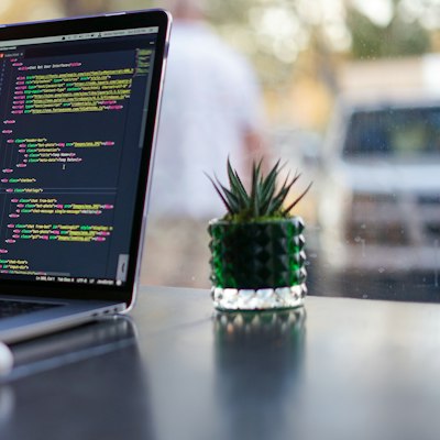 Laptop és monitor kóddal egy íróasztalon